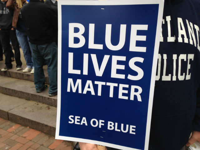 "Blue lives matter" placard and person wearing Cleveland Police jacket at "Sea of Blue" rally in Cleveland, Ohio, Dec. 27. 2014 © WOIO | wtvm.com