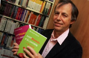 Bernard Maris in 2006 holding the books he authored Antimanuel dâéconomie, Vol. 1 and 2 © rift26.centerblog.net/